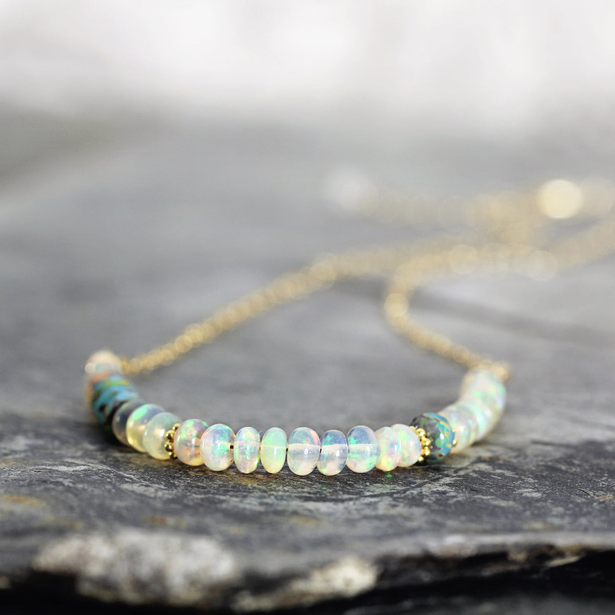Opal beaded necklace on a dark stone surface