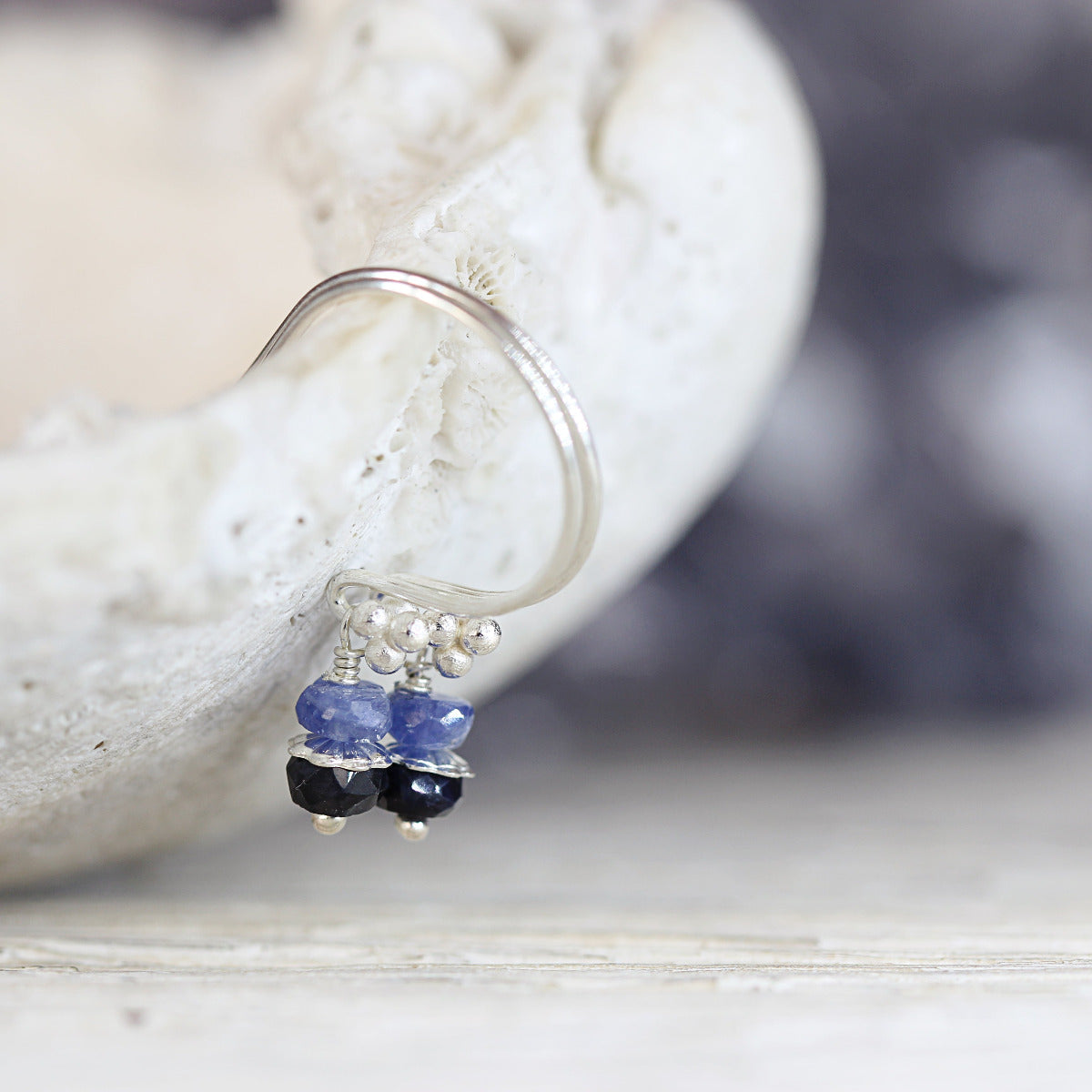 Silver Earrings with Blue Sapphires on a stone background