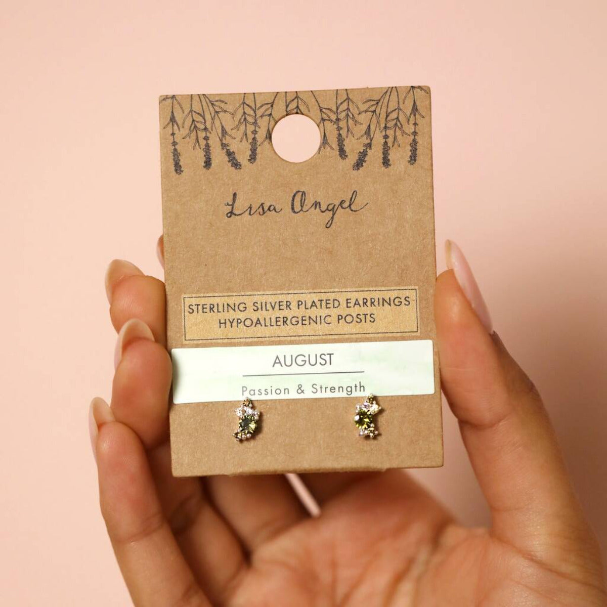 A pair of crystal cluster stud earrings dispayed on a gift card with product information which is held in a hand.