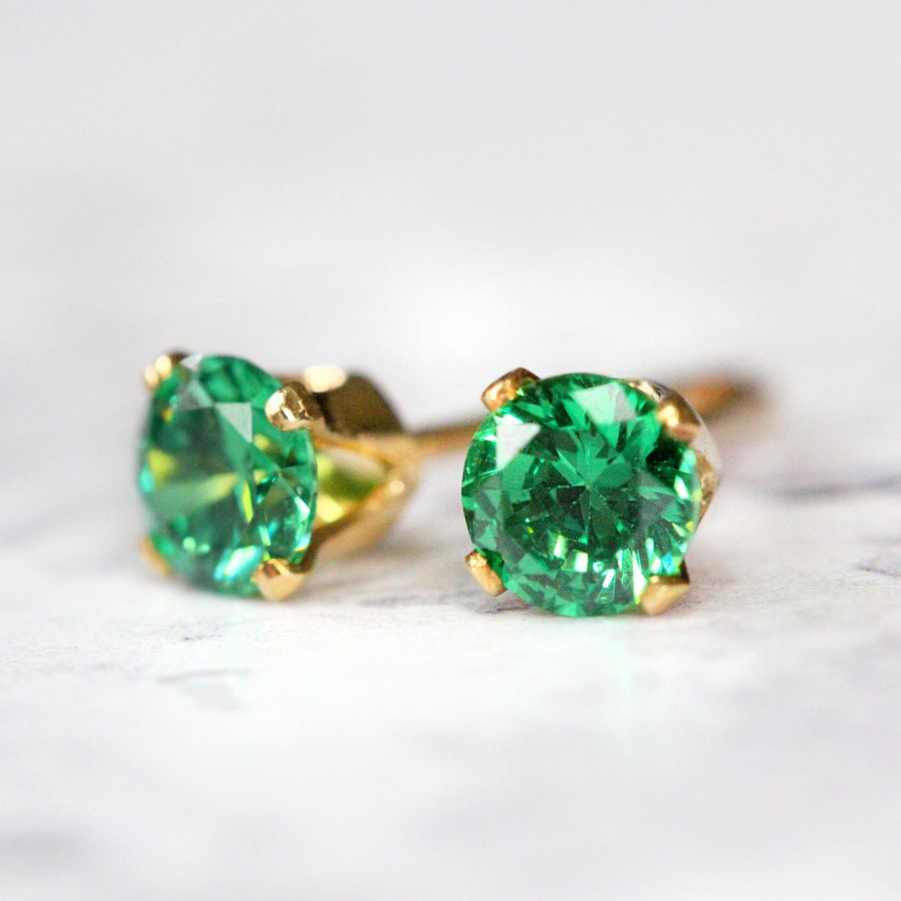 Handmade gold fill stud earrings featuring faceted bright emerald green cubic zirconia gemstones in a prong setting. Round in shape, with ear post fitting and matching butterfly backs. The earrings are simple minimal and elegant in style, and come in various sizes.