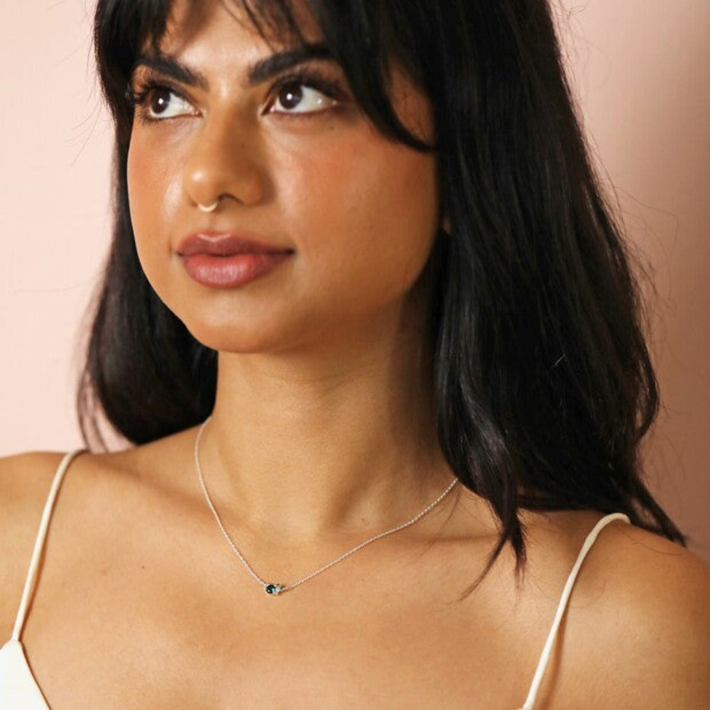 Dainty Blue and silver crystal necklace worn by a woman in a white vest top.