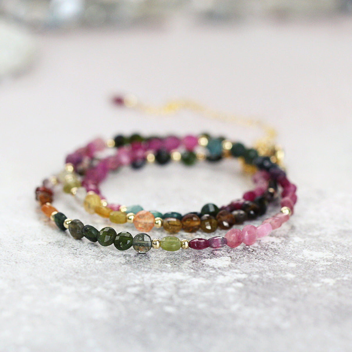 A multicolored tourmaline beaded necklace on a light surface