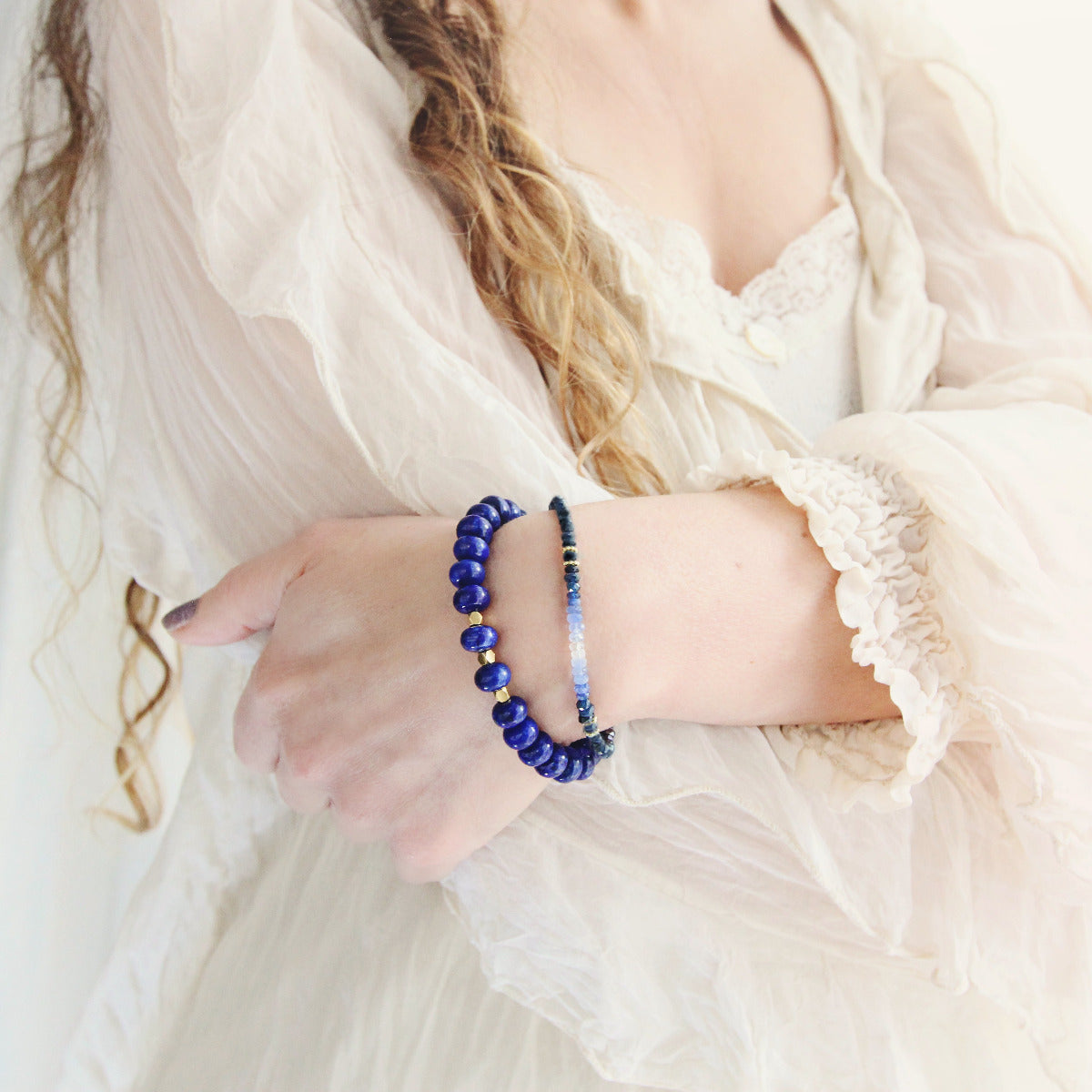 Person wearing a blue beaded sapphire bracelet