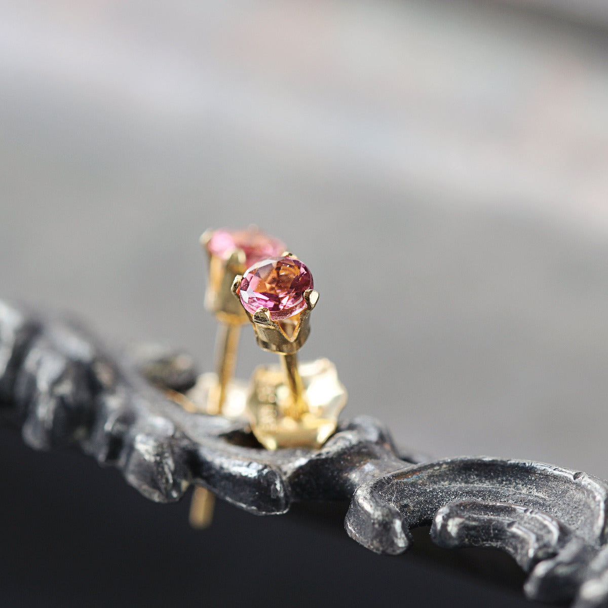 Matching gemstone stud earrings in a gold setting. The tourmaline gemstone is round, faceted, sparkling and rose pink in colour. The stones are set into 14k gold fill ear posts with a 4 prong setting with matching butterfly backs.