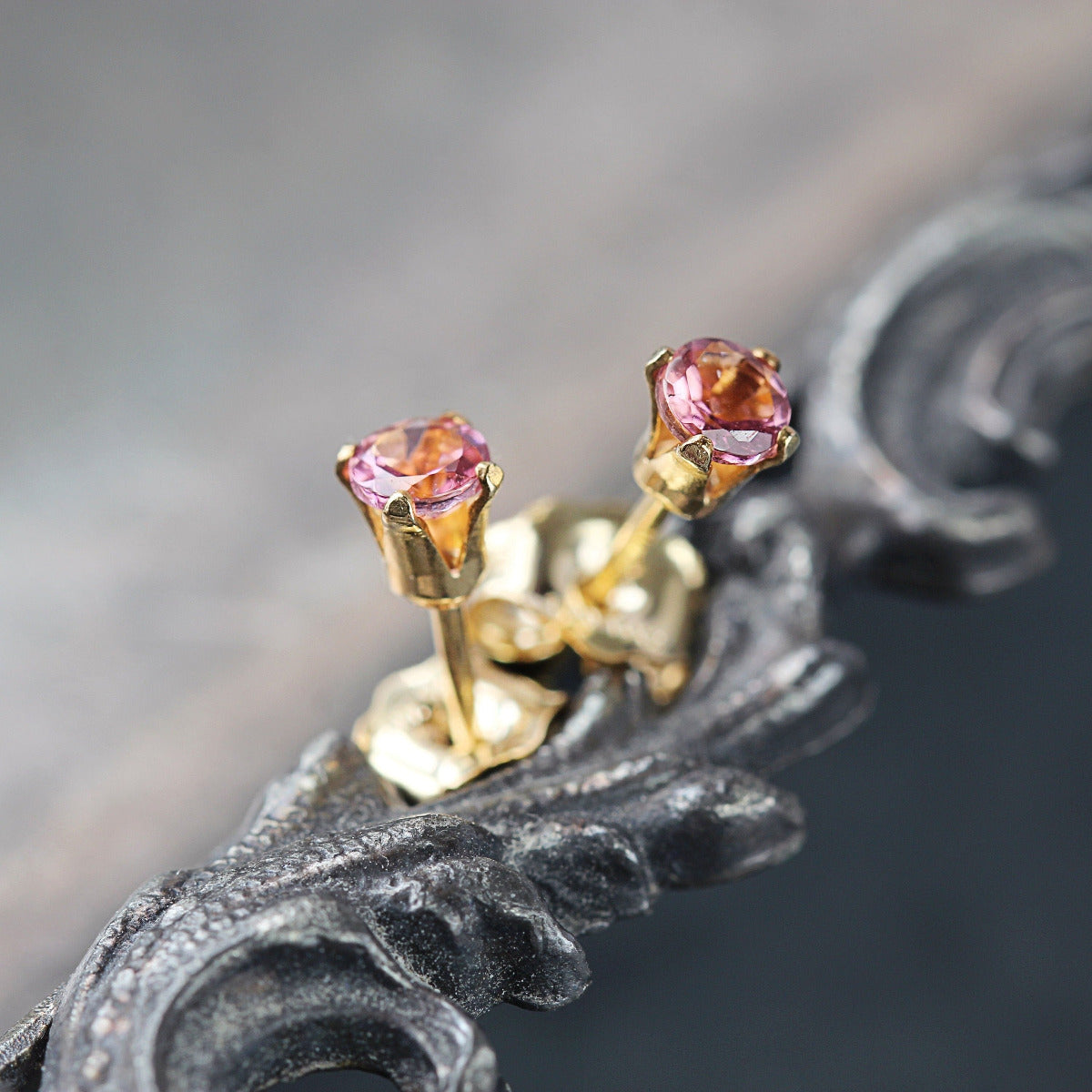 A pair of gold handmade stud earrings featuring rich rose pink Tourmaline gemstones prong set into 
a round ear post. They are round in shape, with a post fitting and butterfly backs. The earrings are dainty, simple in style.