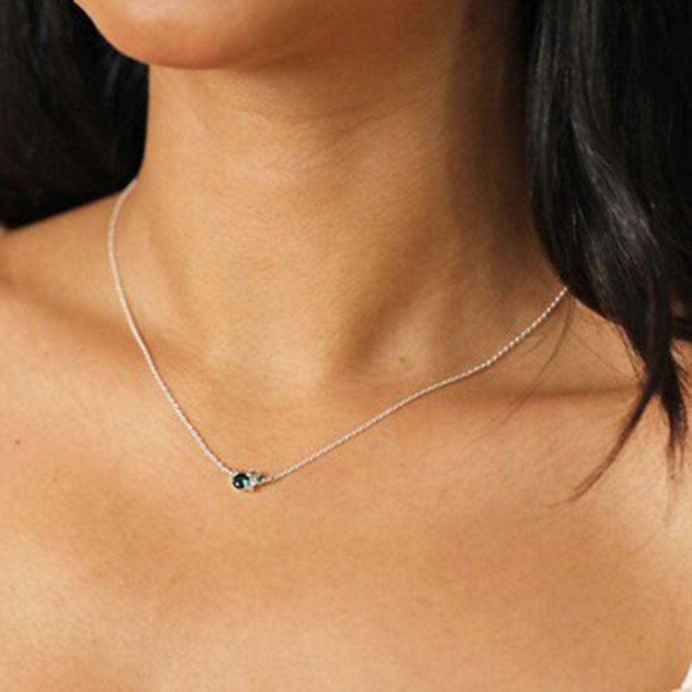 Woman wearing blue cubic zirconia crystal necklace with silver chain.