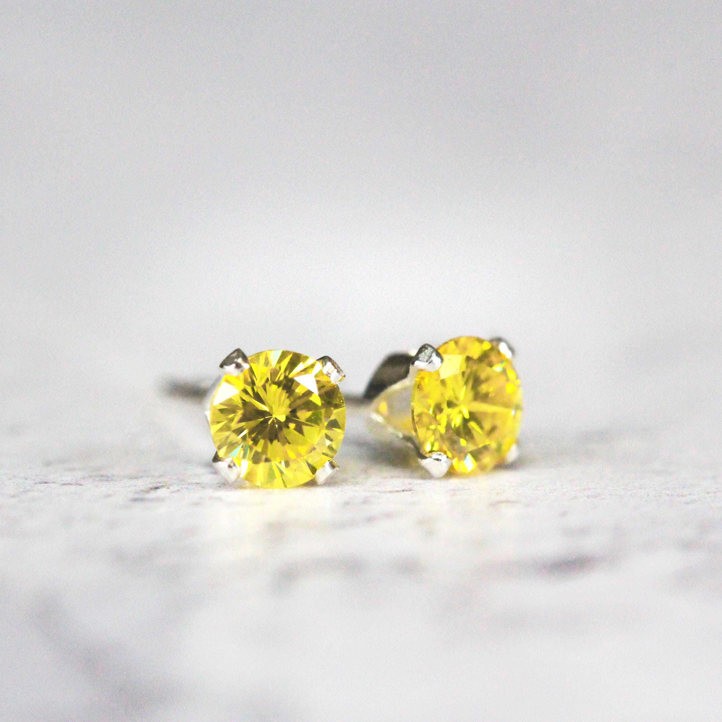 Simple, minimal round stud earrings made with yellow cubic zirconia gemstones set into sterling silver ear posts. Available in various sizes including 3 milimetres diameter, 4 milimetres diameter, 5 milimetres diameter and 6 milimetres diameter.