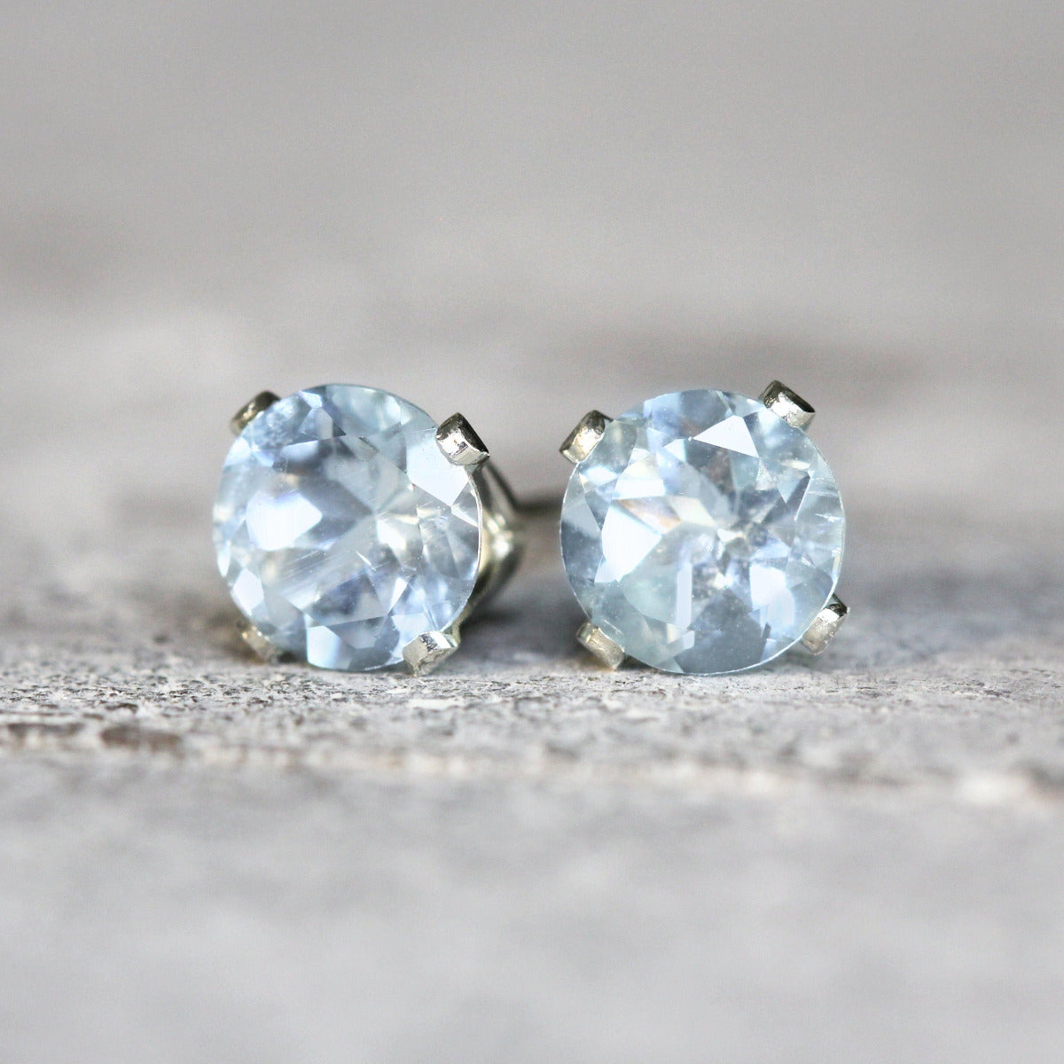 Simple, minimal round stud earrings made with aquamarine gemstones set into sterling silver ear posts. Available in various sizes including 3 milimetres diameter, 4 milimetres diameter, 5 milimetres diameter and 6 milimetres diameter.